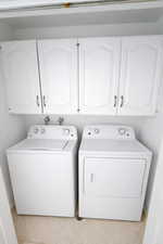 Laundry area featuring cabinet space and separate washer and dryer