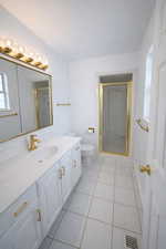 Bathroom featuring a stall shower, vanity, light tile patterned flooring, and a textured ceiling