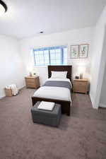 Carpeted bedroom with a textured ceiling and baseboards