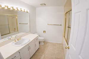 Bathroom featuring enclosed tub / shower combo, vanity, and light tile patterned floors