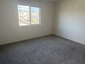 Carpeted empty room with baseboards