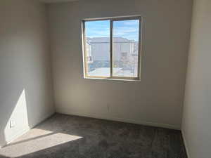 Carpeted empty room with baseboards