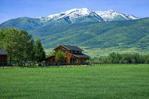 Photo from the front of the property looking west from the paved road.  Structures in the photo are of the neighbors next door to the property.