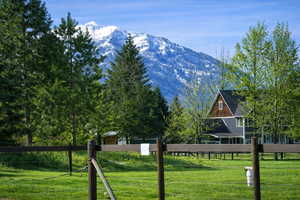 Photo is on the southeast corner of the property looking to the southwest, from the paved road.  The home in the photo is the neighbors property, but the fence and green grass up to the next fence in the photo is the subject property.