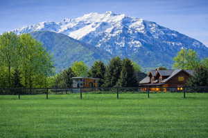 Photo from the front of the subject property looking southwest from the paved road.  Structures in the photo are of the neighbors next door to the property.