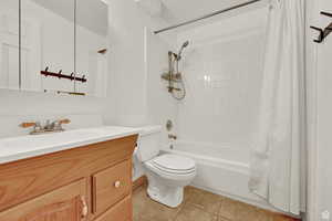 Full bathroom with vanity, shower / bath combo, and light tile patterned flooring