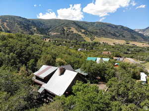 Aerial view of property and surrounding area featuring a mountain backdrop