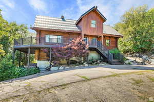 View of front of home featuring log exterior and a chimney