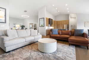 Living room with light wood-type flooring and vaulted ceiling
