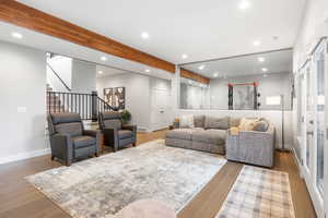 Living area featuring recessed lighting, beam ceiling, and light wood-style floors