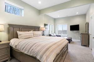 Bedroom with light colored carpet and recessed lighting