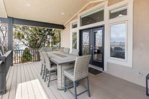 Wooden terrace featuring outdoor dining space and french doors