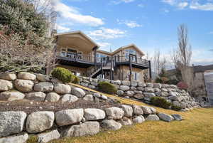 Rear view of property featuring a chimney and a deck