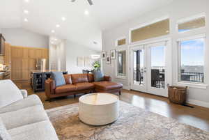 Living room featuring wood finished floors, vaulted ceiling, ceiling fan, french doors, and recessed lighting