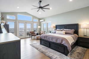 Bedroom featuring light wood-type flooring, access to outside, french doors, a high ceiling, and ceiling fan