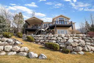 Rear view of house featuring a deck and stucco siding
