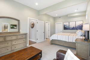 Bedroom featuring light colored carpet, beam ceiling, and recessed lighting