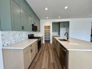 Kitchen featuring a kitchen island with sink, stainless steel appliances, light stone countertops, dark wood-style flooring, and tasteful backsplash