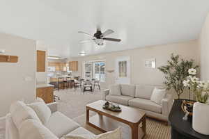 Living area with a ceiling fan and light carpet