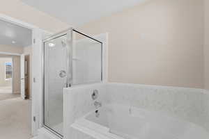 Full bath with a shower stall, a garden tub, and carpet