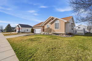 Single story home with concrete driveway, an attached garage, and stucco siding