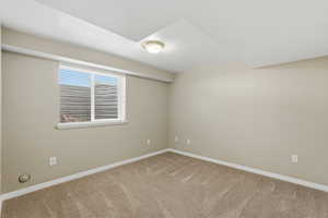 Unfurnished room with baseboards and light colored carpet