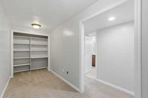 Walk in closet featuring light carpet