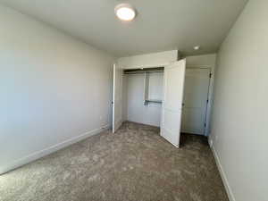 Unfurnished bedroom with carpet flooring and a closet