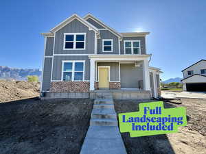 View of front facade with a mountain view, covered porch, board and batten siding, and brick siding
