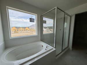 Bathroom with a garden tub, a shower stall, and marble finish floors