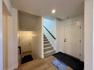 Entrance foyer with stairs and light wood finished floors