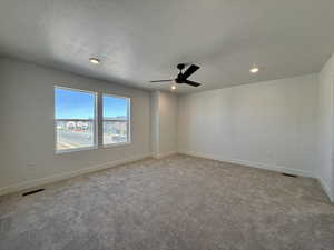 Unfurnished room with carpet, a ceiling fan, a textured ceiling, and recessed lighting