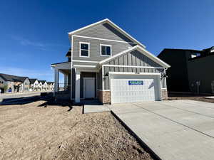 View of front of property featuring a garage, driveway, board and batten siding, a residential view, and covered porch