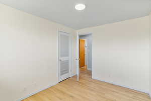 Unfurnished room with light wood finished floors and baseboards