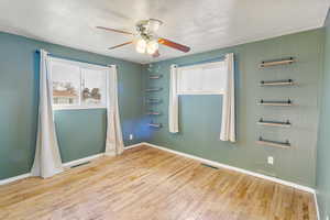 Unfurnished room featuring light wood-type flooring, ceiling fan, and a textured ceiling