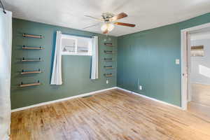 Unfurnished room featuring light wood-style floors, ceiling fan, and a textured ceiling