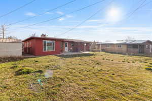 Rear view of house with a fenced backyard, a patio, and an outdoor structure
