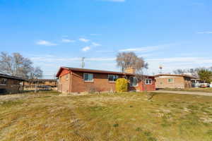 View of front facade featuring brick siding, a chimney, and crawl space
