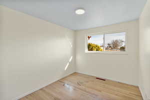 Spare room with light wood-style flooring and baseboards