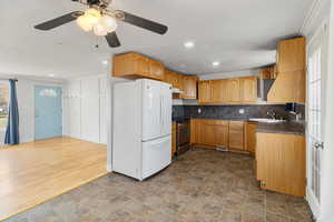 Kitchen featuring dark countertops, freestanding refrigerator, and healthy amount of natural light