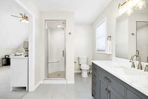 Bathroom with vanity, a shower stall, and ceiling fan