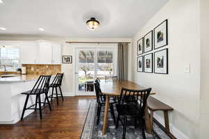 Dining room with dark wood finished floors and recessed lighting