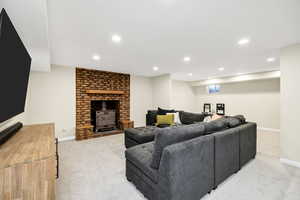 Living room with recessed lighting, light carpet, and a wood stove