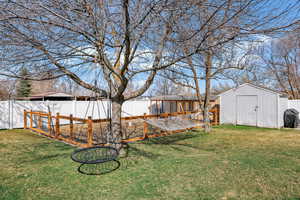 Fenced backyard featuring a storage shed