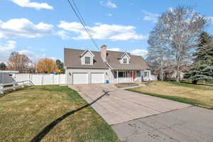 Cape cod home with covered porch, driveway, a chimney, roof with shingles, and an attached garage