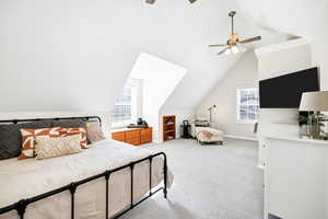 Bedroom with lofted ceiling, light carpet, and a ceiling fan