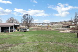 View of yard featuring an outdoor structure, a pole building, and a wooden deck