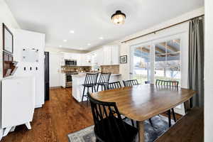 Dining room featuring dark wood-style floors and recessed lighting