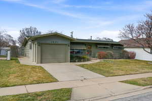 View of front of house with an attached garage and driveway
