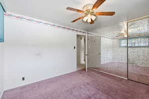 Unfurnished bedroom with carpet, ceiling fan, and a closet
